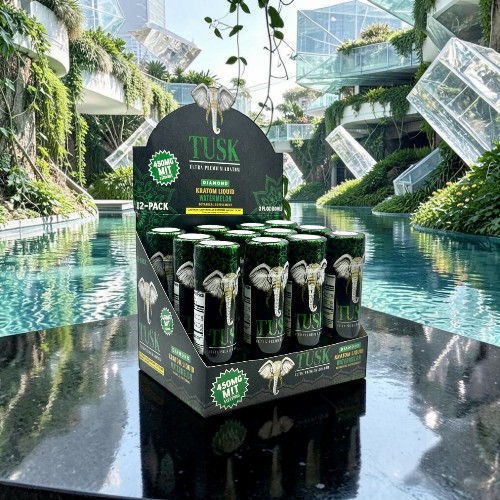 Display of energy drink bottles near a serene pool setting.