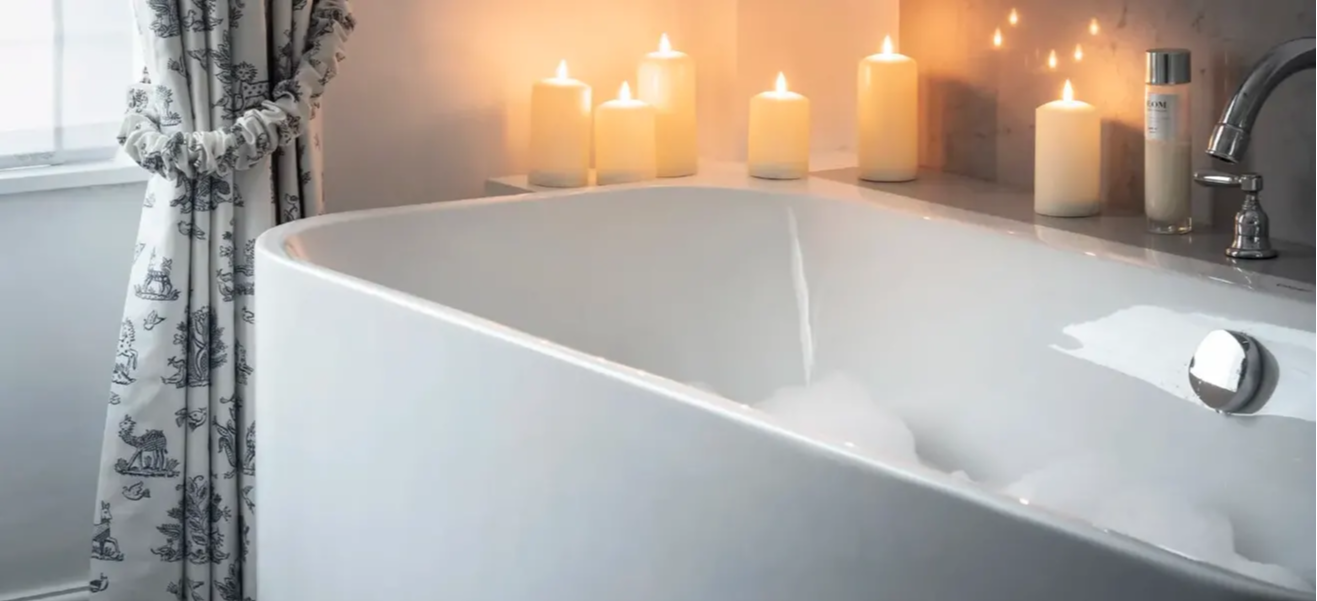 Illuminated candles surrounding bath.