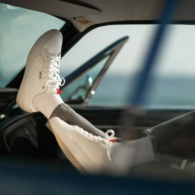 feet on dashboard of car wearing levi's shoes