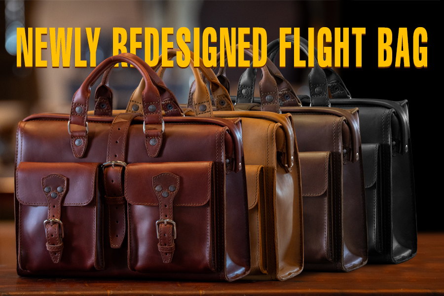 Four redesigned flight bags in various colors displayed on a table.