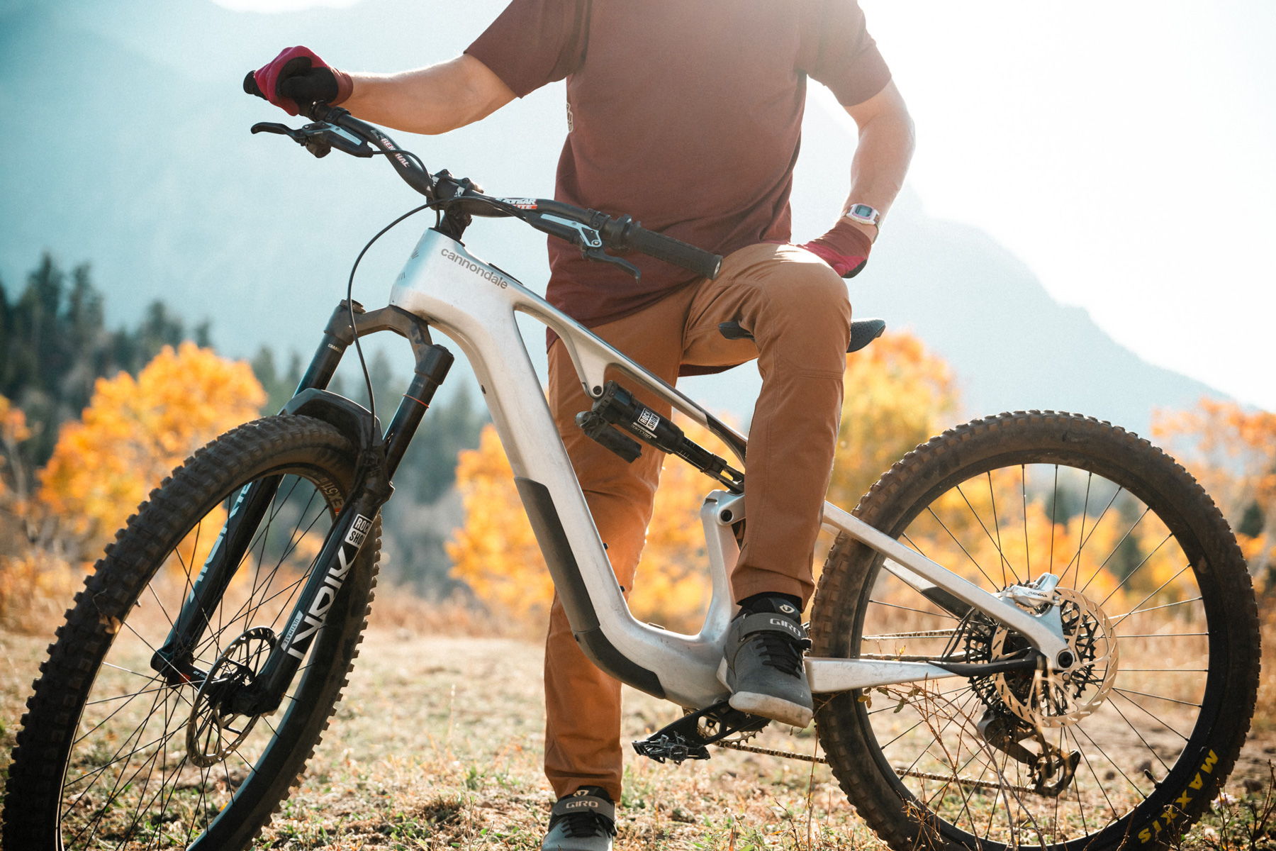 Person riding a mountain bike in an outdoor setting with autumn foliage.