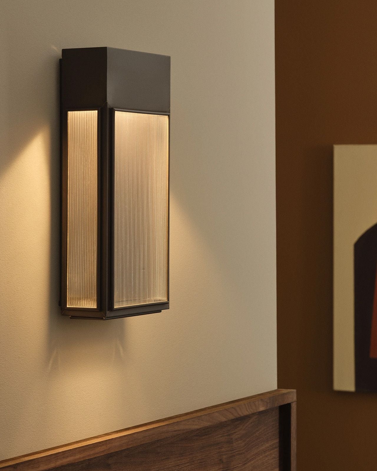 Ribbed Glass & Brass Wall Light Bronze in a hallway installed above a timber feature wall