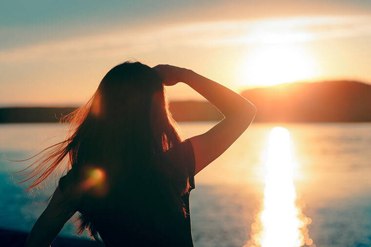 Woman Looking At The Sunset With Her Hand Over Her Face