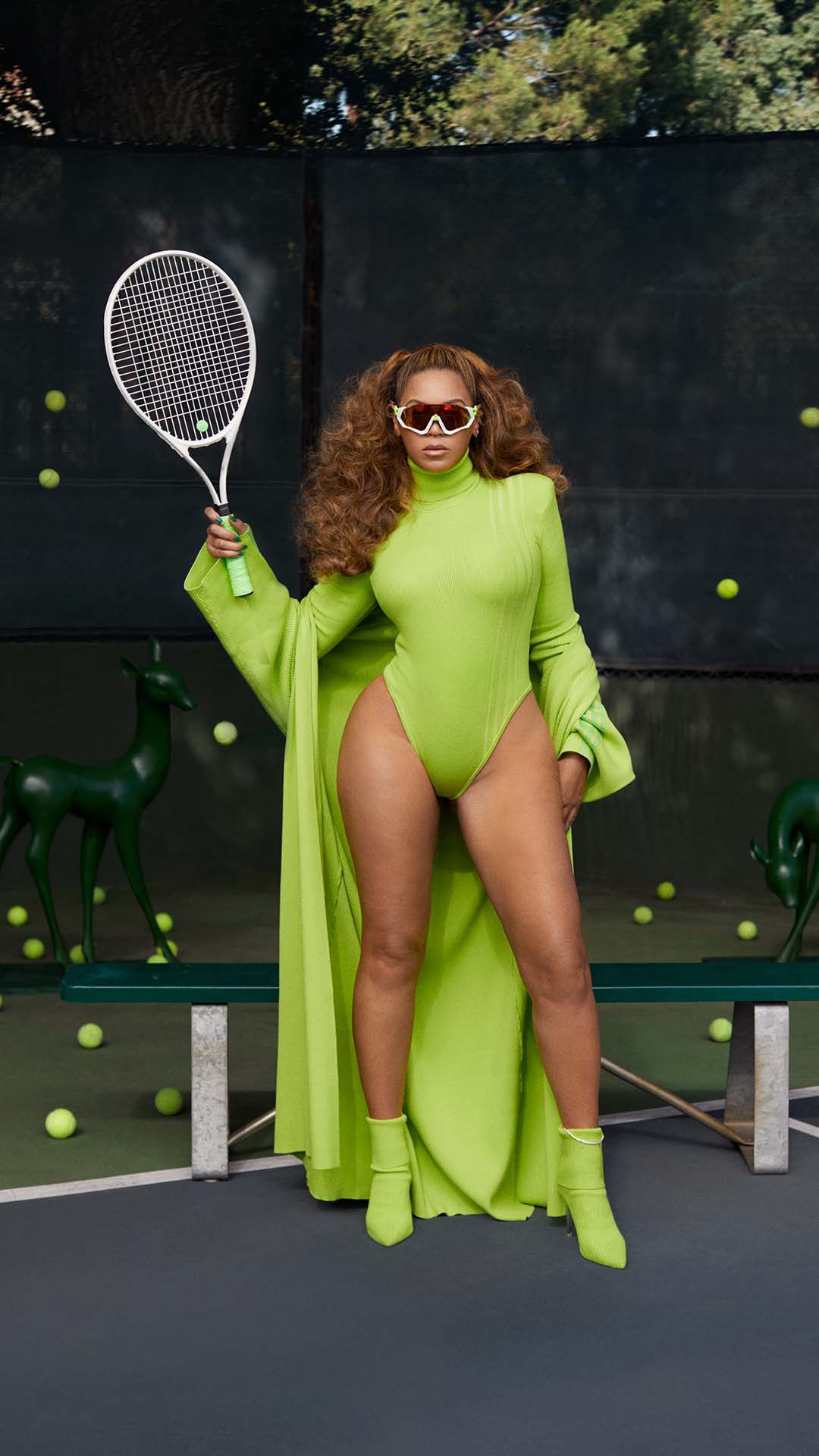 beyonce posing with tennis racket on tennis court