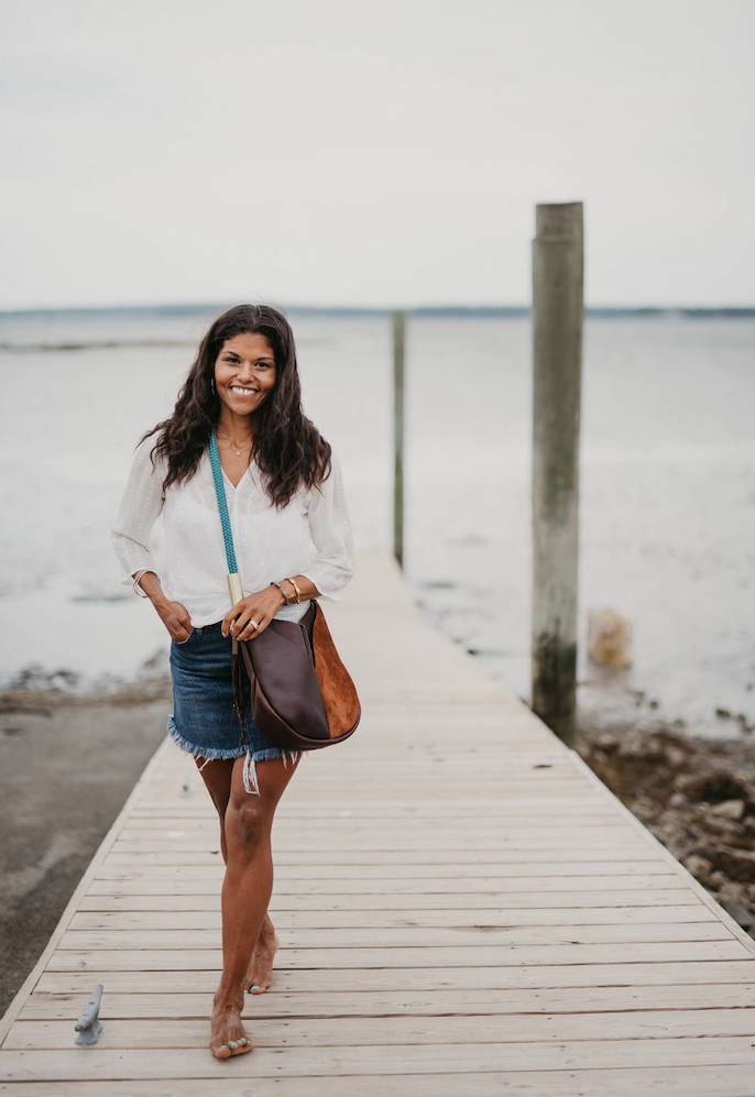 woman smiling while holding bag on the dock
