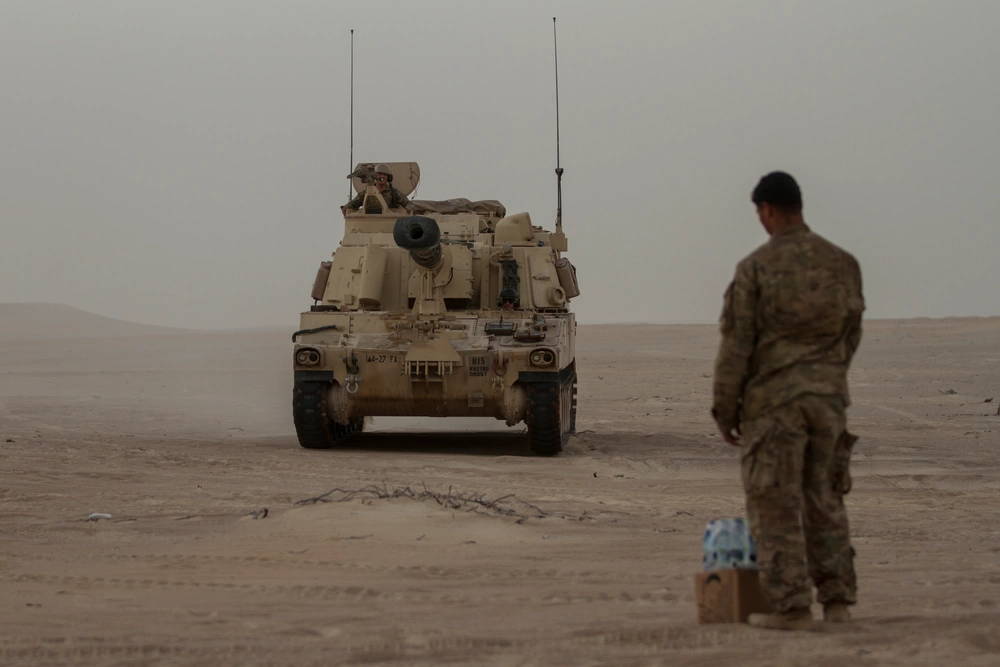 An M109 Paladin crew from 4th Battalion, 27th Field Artillery Regiment, 2nd Brigade Combat Team, 1st Armored Division, Fort Bliss, Texas, picks up a resupply of water and meals, ready to eat during Iron Union 18-6 in the United Arab Emirates, Jan. 23, 2018. Iron Union is a recurring exercise focusing on combined arms, security, and staff operations. It is designed to strengthen military-to-military relations between the U.S. and the UAE land forces. It is a training opportunity for both countries to build tactical proficiency in critical mission areas, gain an understanding of each other's forces, and support long-term regional stability. (U.S. Army photo by Sgt. Thomas X. Crough, U.S. ARCENT PAO)