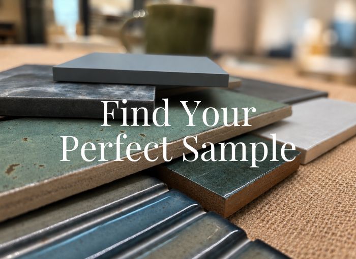 A stack of tile samples in various colors and textures, including matte gray, speckled green, glossy blue, and ribbed teal.