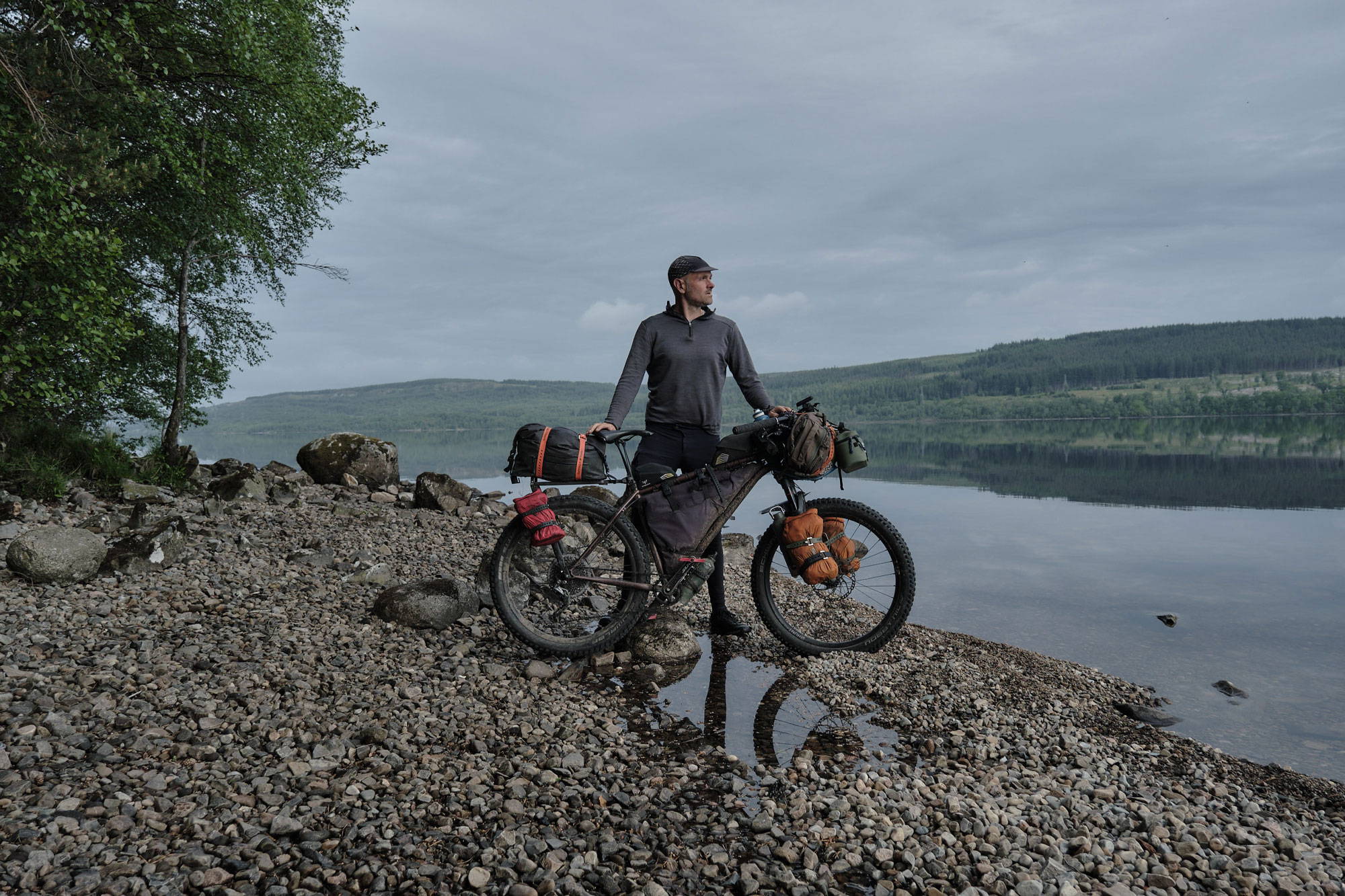 Andy Cox posing with his bike near a lake