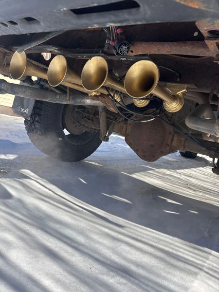 Close-up underside view of brass Conductor's Special 127H train horn bells mounted under James' 2001 Silverado 2500HD, install photo 4
