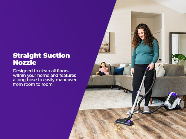 Woman vacuuming a room with a straight suction nozzle.