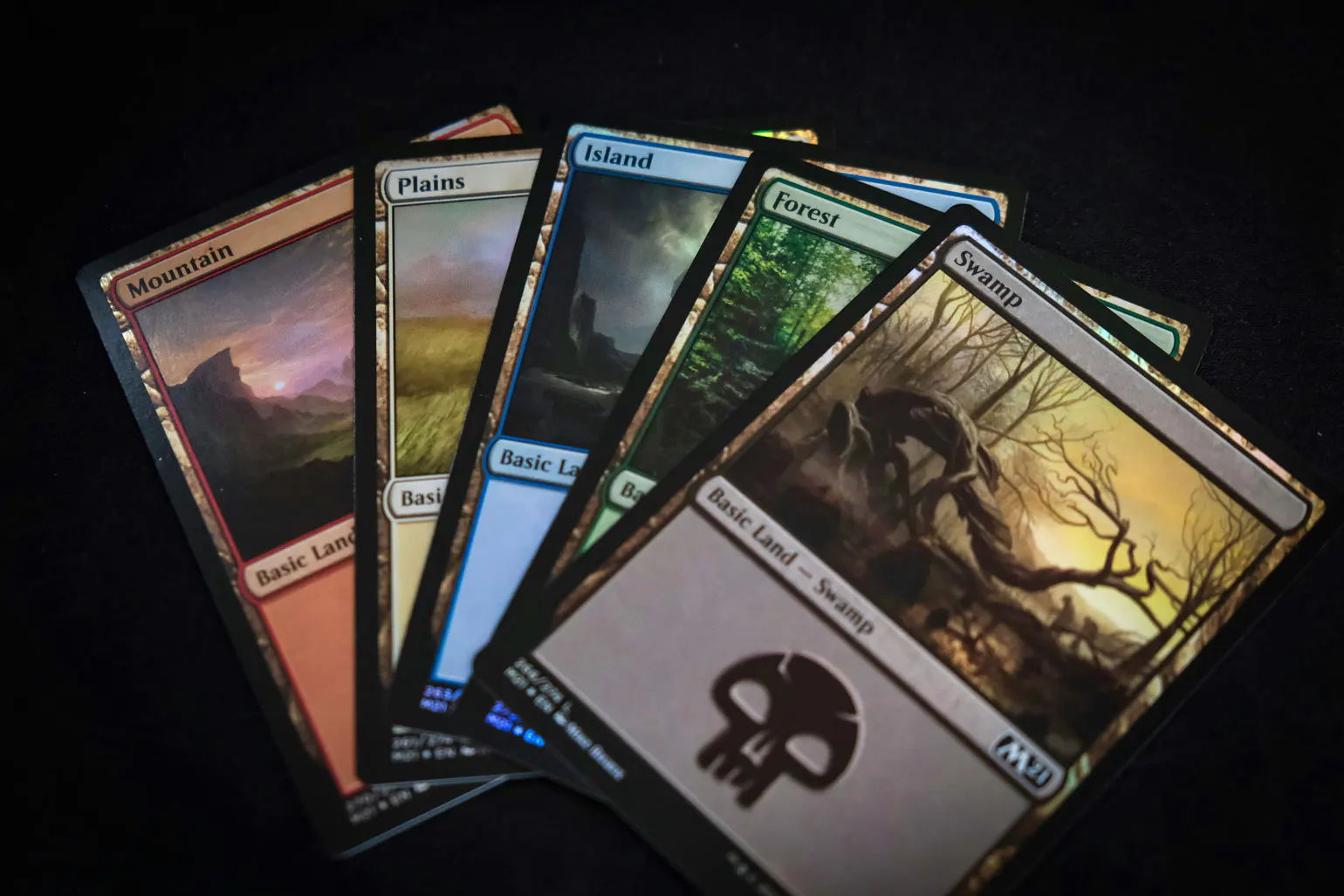 magic the gathering rules - A collection of colorful trading cards arranged on a dark surface.