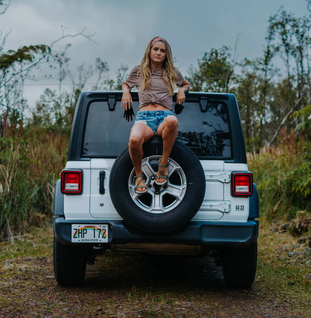 woman sitting on car in stylish outdoor sandals