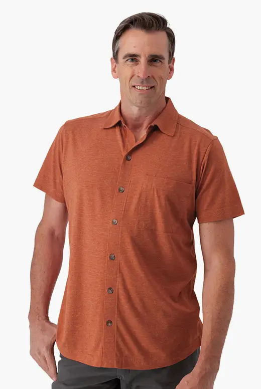 Man wearing an orange short-sleeve button-up shirt, smiling.