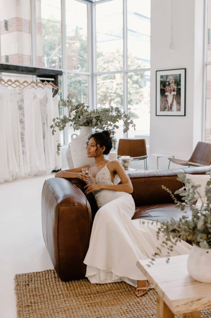 La mariée dans la boutique Grace Loves Lace à Toronto sur un canapé en cuir brun