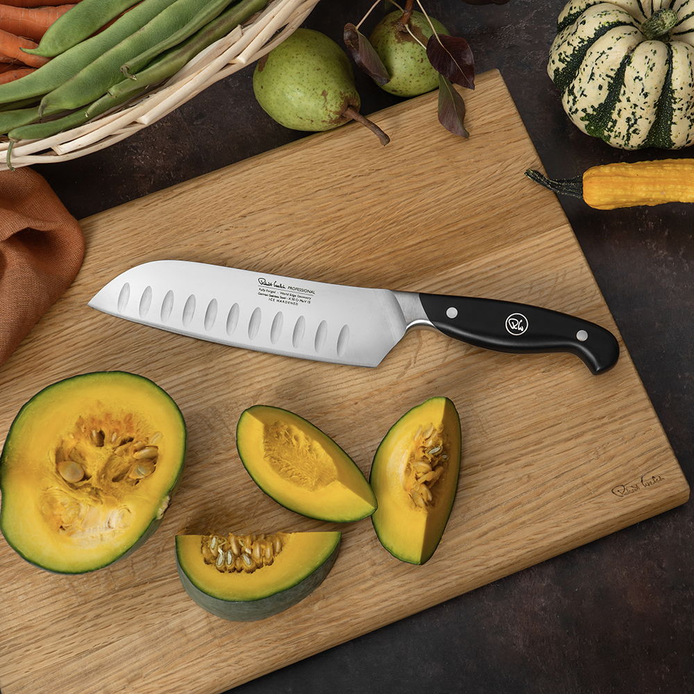 17cm Professional Santoku Knife beside cut squash on a wooden cutting board.