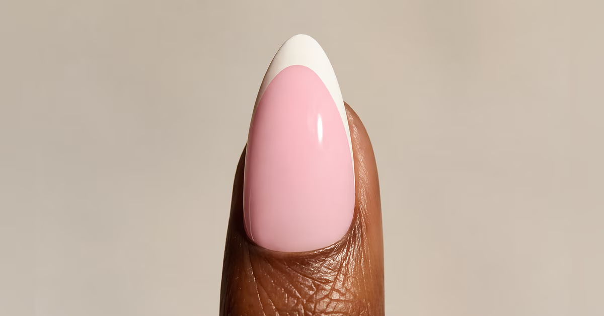 A finger with pink and white nail polish.