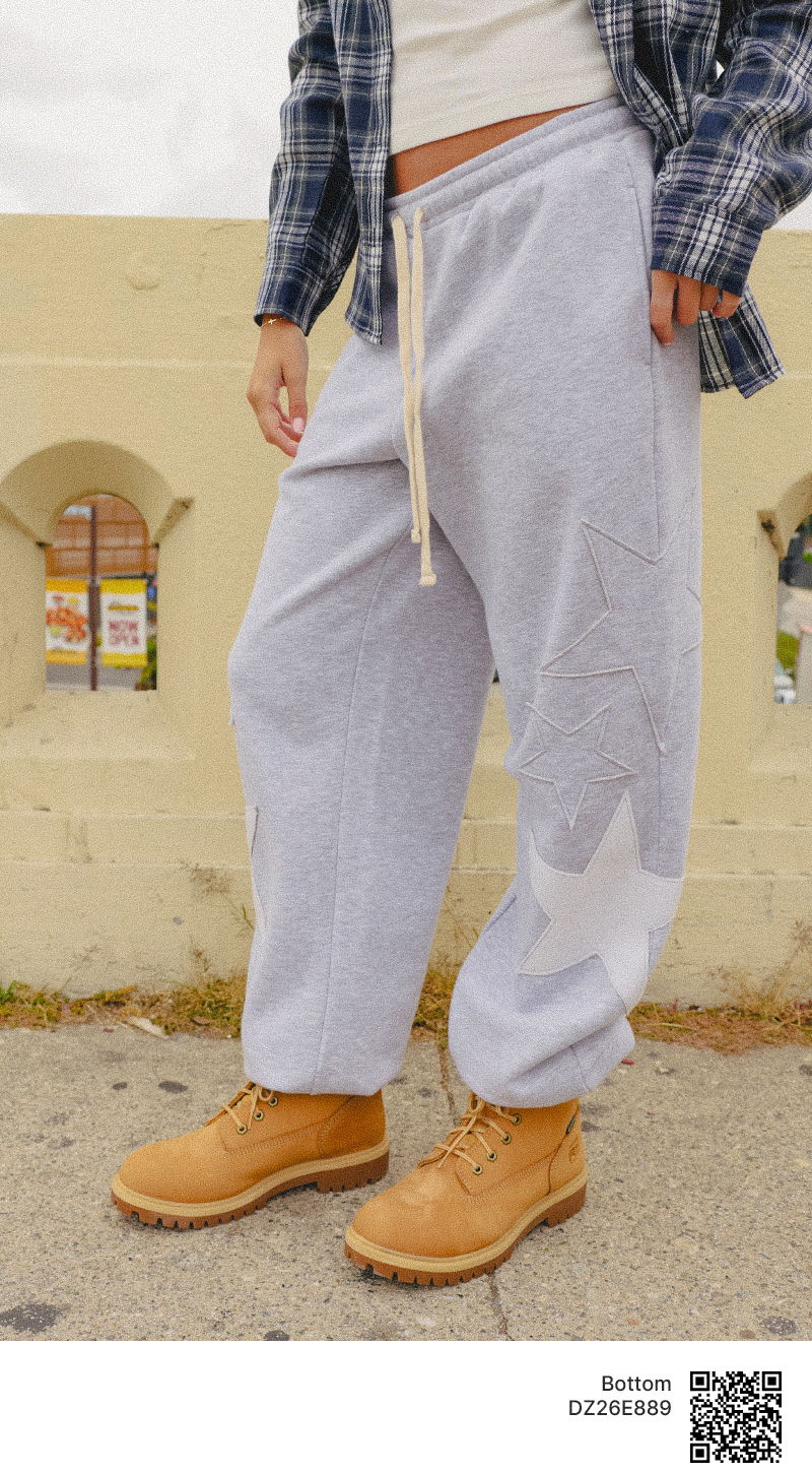 Person wearing gray sweatpants and tan boots, standing outdoors.