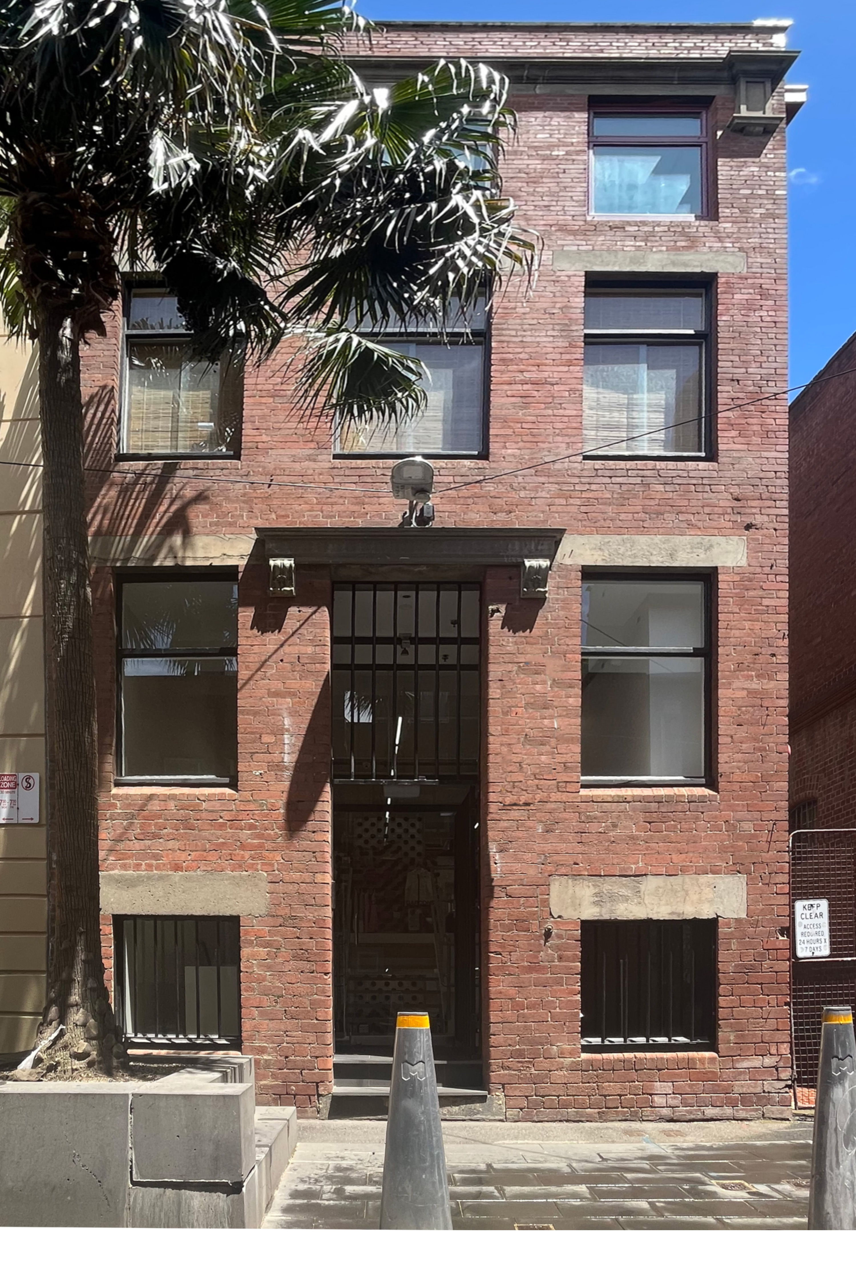 COMME des GARÇONS Melbourne Store, red brick building with palm tree out the front