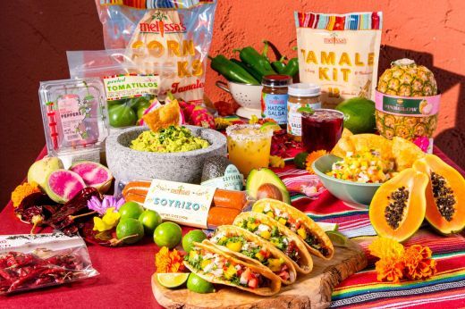 Colorful spread of tacos, fruits, and ingredients for a festive meal.