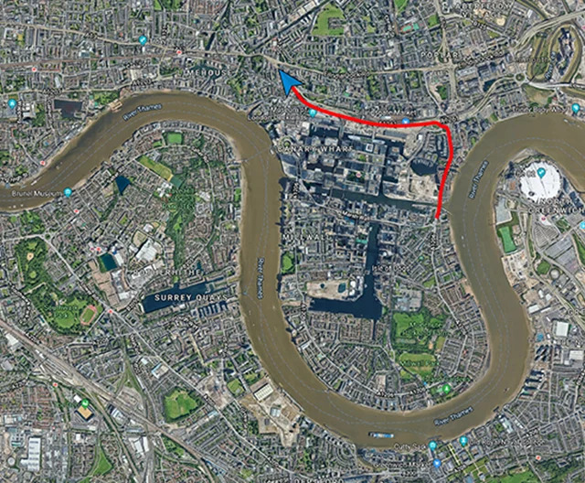 Aerial view of a city with a winding river and marked route.