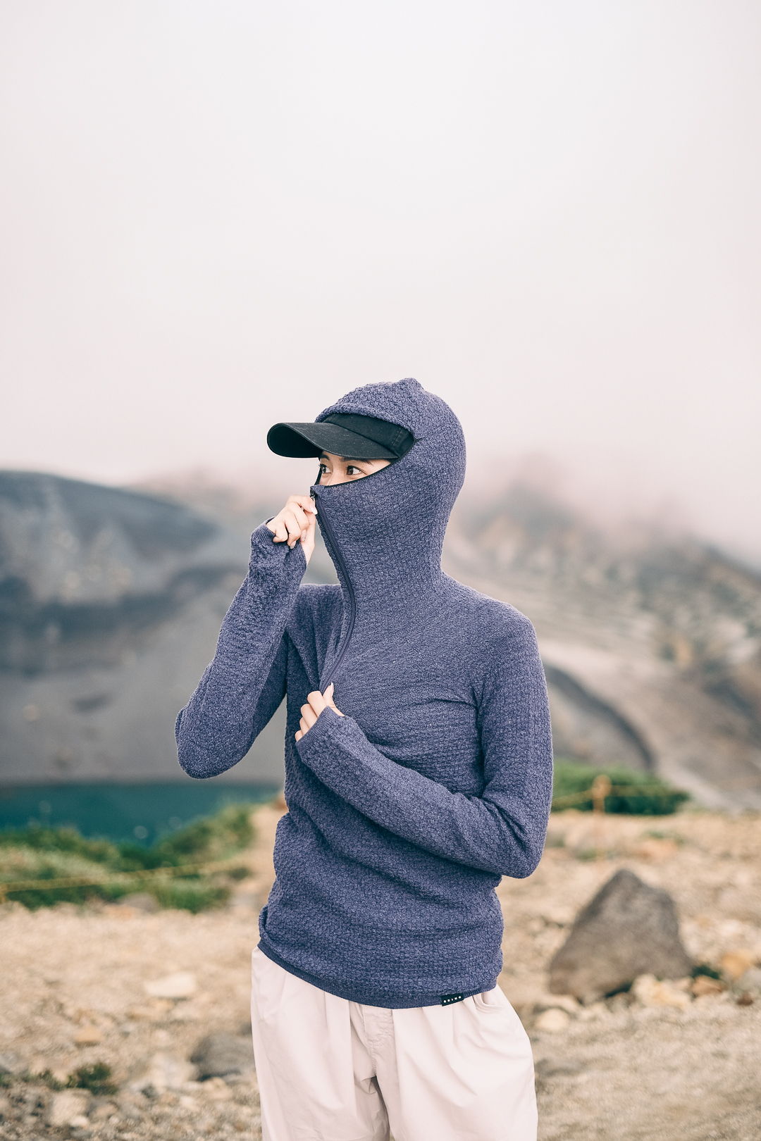 Person wearing a purple hooded sweater in a misty outdoor setting.