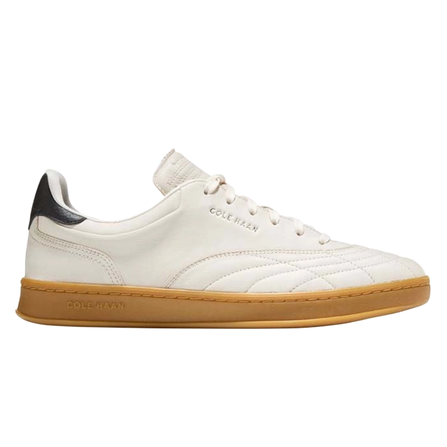 White sneaker with gum sole and black heel accent.