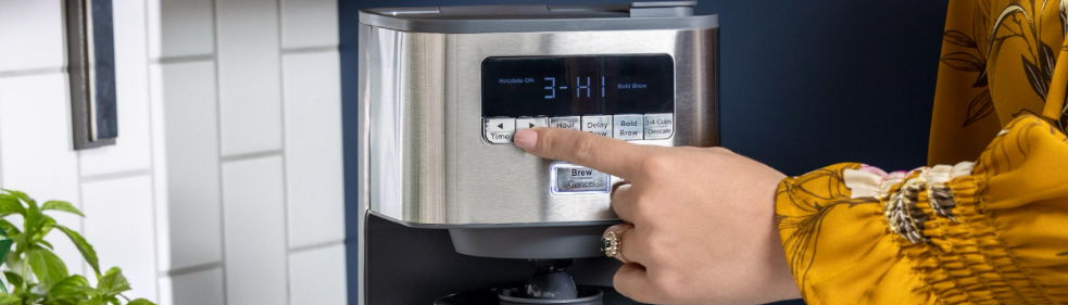 Person pressing a button on a modern appliance.