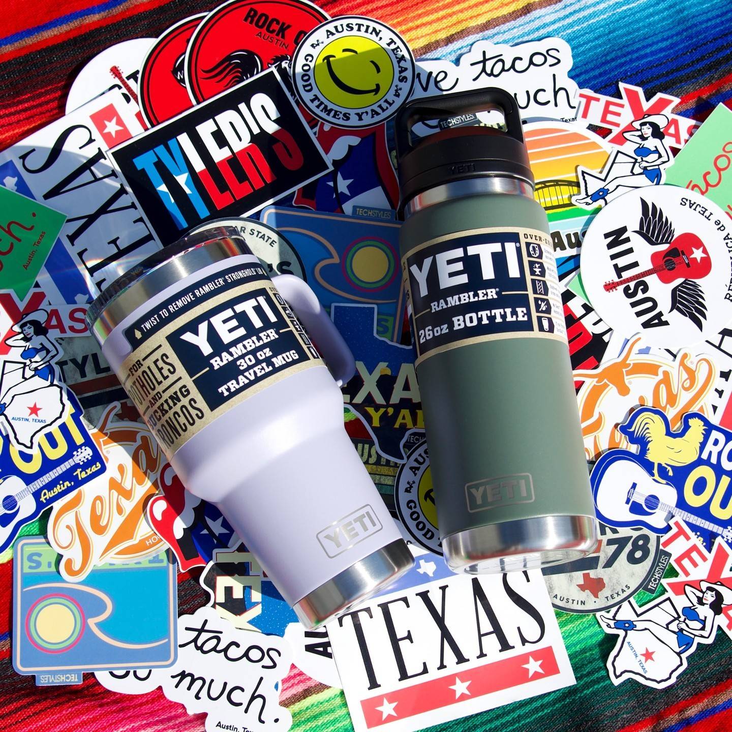 A Yeti Bottle and Rambler sit atop a pile of texas and Austin based stickers