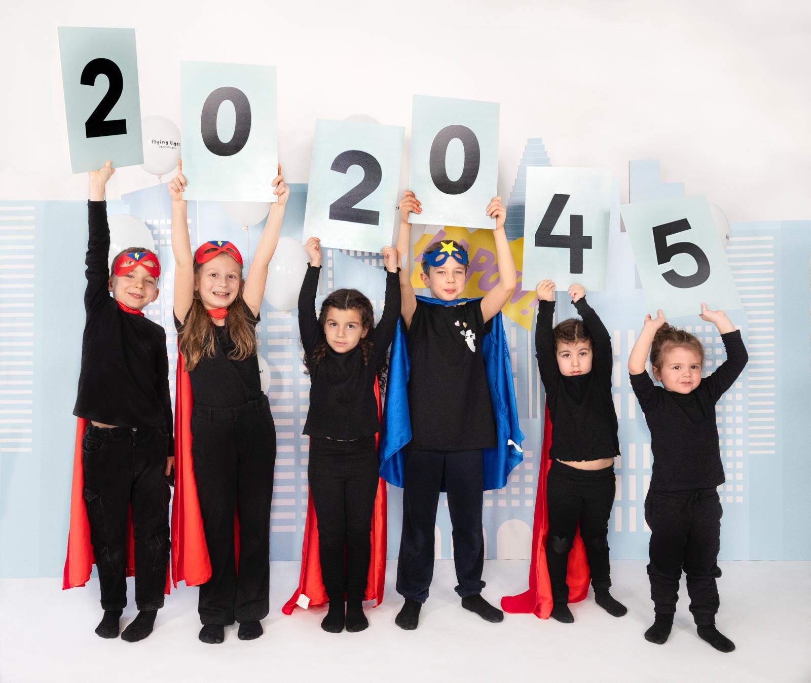 Niños vestidos como superhéroes con los números 202045 en un contexto de ciudad.