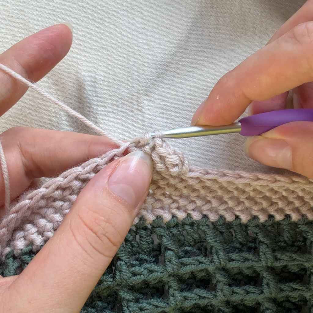 Halbes Fischgrät-Stäbchen. Schritt 5: die erste Masche wird durch die zweite geholt.