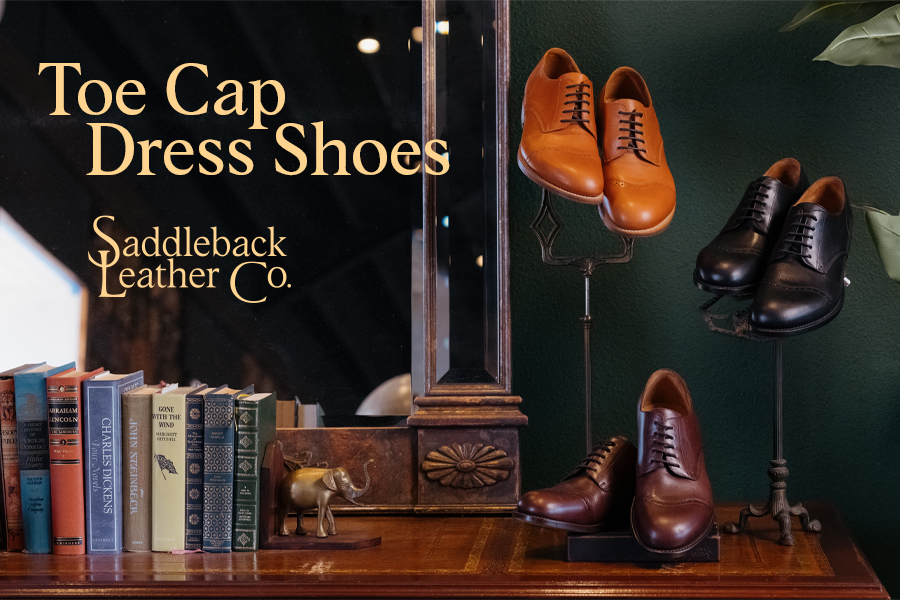 Toe cap dress shoes displayed with books and Saddleback Leather Co branding.