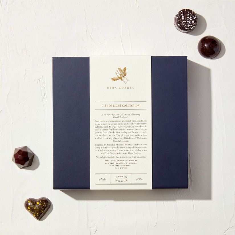 A box of chocolates with a decorative label and assorted chocolate pieces.