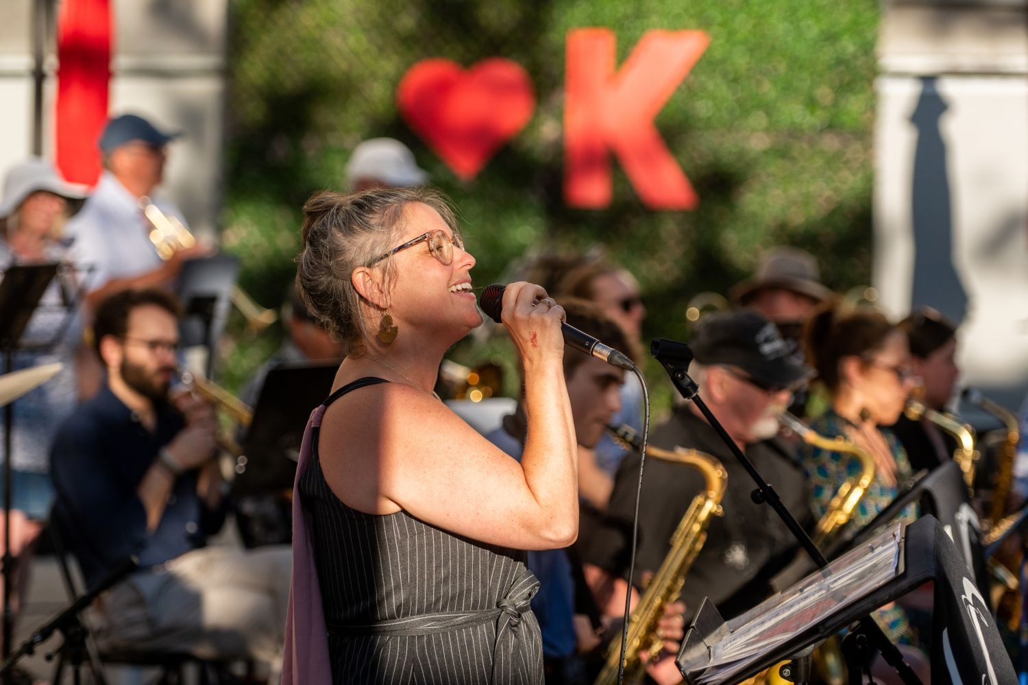 A woman sings in front of a band with 