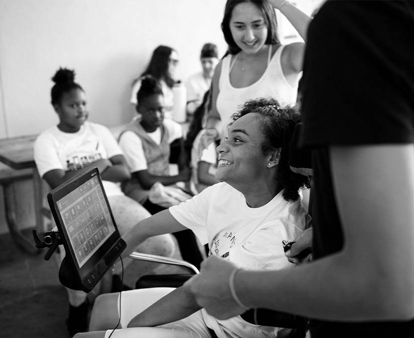 A girl using her Tobii Dynavox device to communicate in a classroom