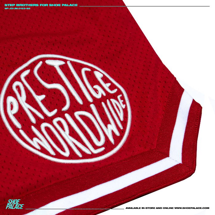 closeup of embroidered prestige worldwide on red mesh shorts