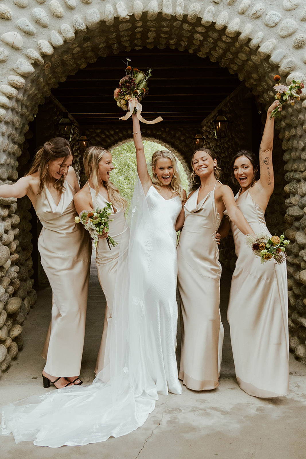 Bride and her bridesmaids wearing champagne coloured dresses.
