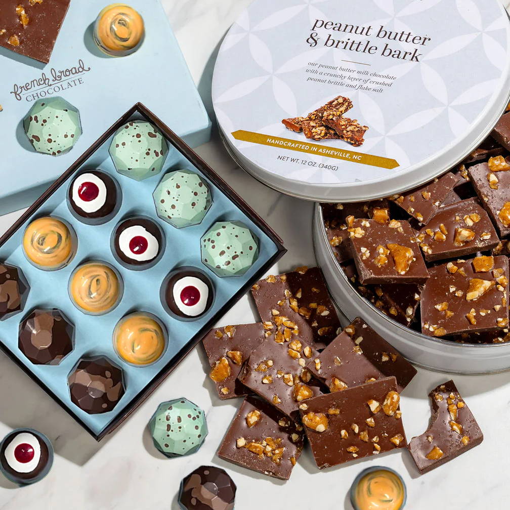 Assorted chocolates and peanut butter bark on a marble surface.