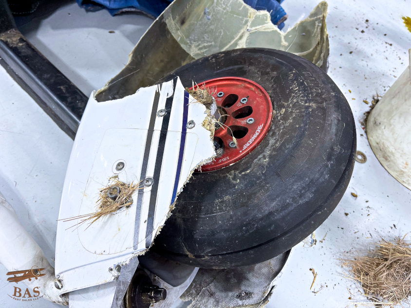 A damaged wheel with a red rim and debris around it.