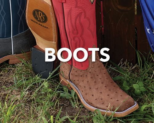 A collection of cowboy boots displayed on grass.