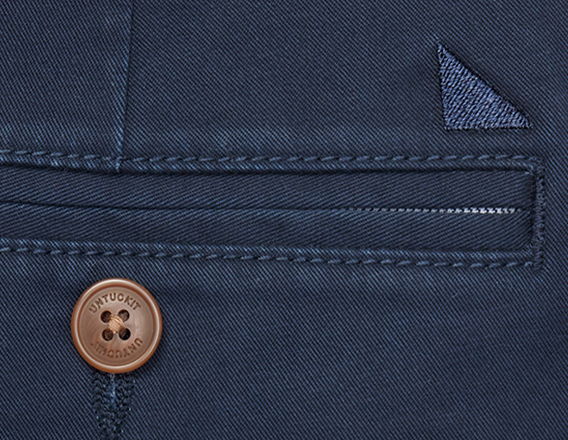 Close-up of a navy fabric with a button and pocket detail.