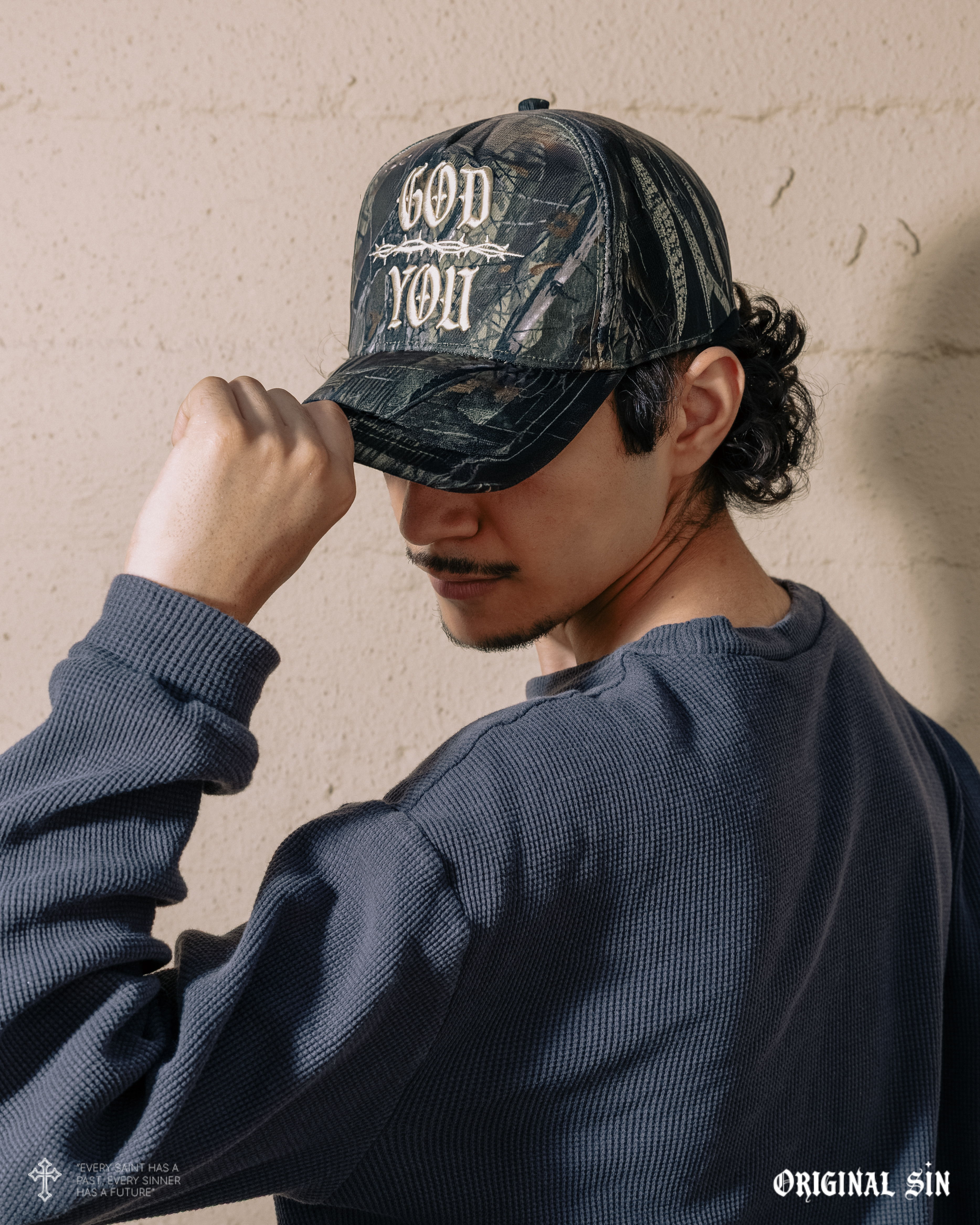 Person wearing a camo cap with 