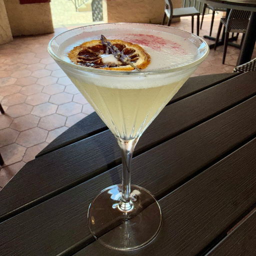 A cocktail in a glass with a decorative orange slice.