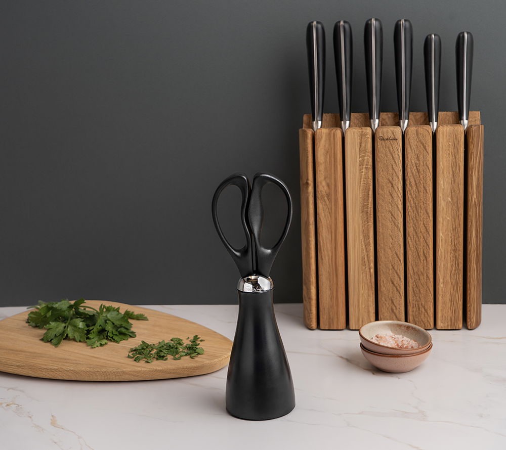 A kitchen scene with Signature Scissors, herbs, a bowl, and Book Oak Knife Block.
