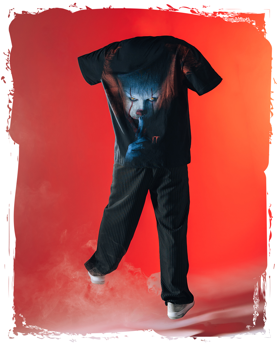 Black t-shirt with graphic design, paired with black pants on a red background.