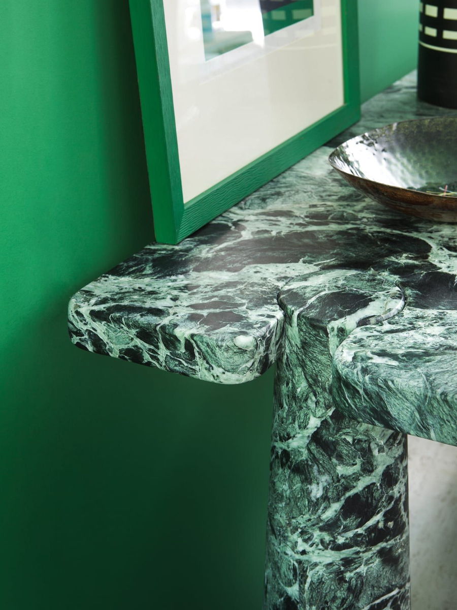 Green marble Eros console table corner with a framed picture and decorative bowl.