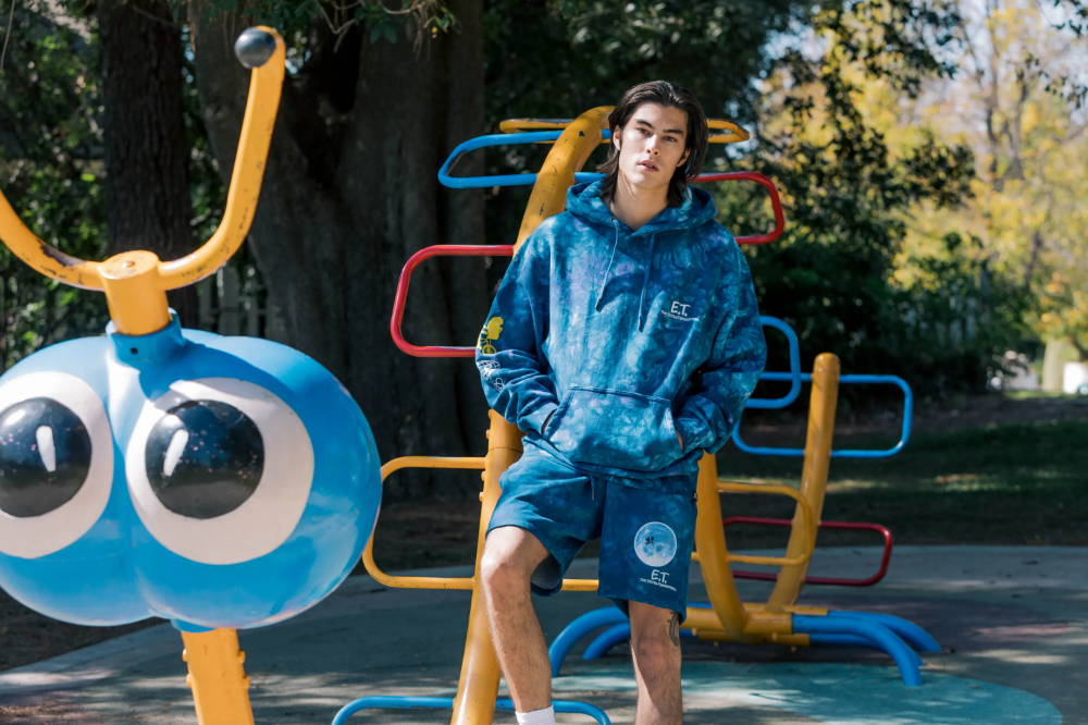 male model in shoe palace x et blue galaxy apparel on playground