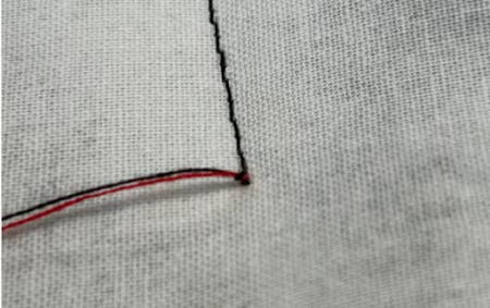 Closeup of the thread tails knot on the quilt top surface