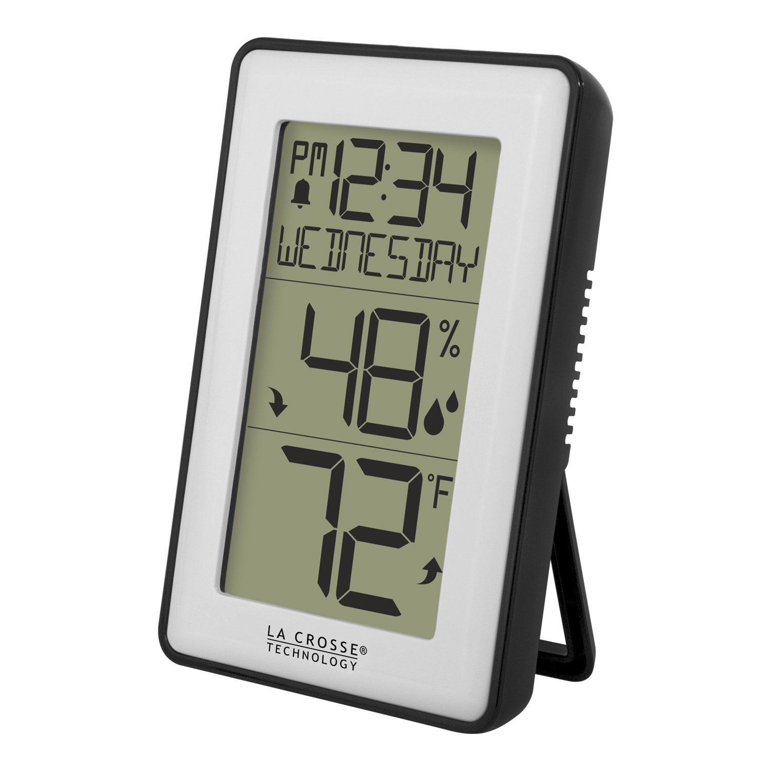 Digital thermometer displaying temperature and humidity next to a plant and kitchen items.