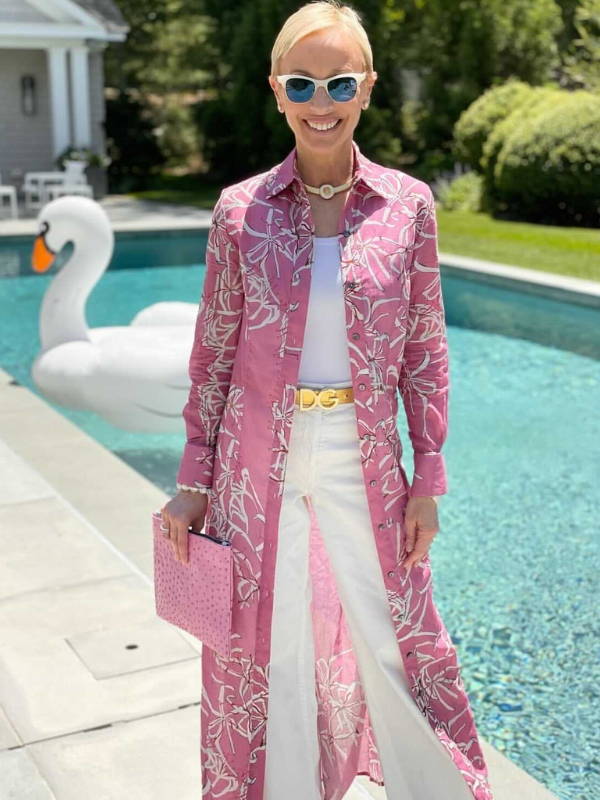 Lisa Frohlich wearing pink cotton shirtdress over white tank top and pants with a gold belt by the pool in the Hamptons by Ala von Auersperg
