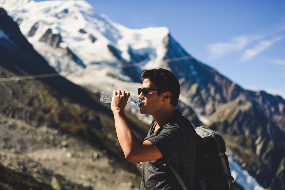 Man drinking water on a mountain hike